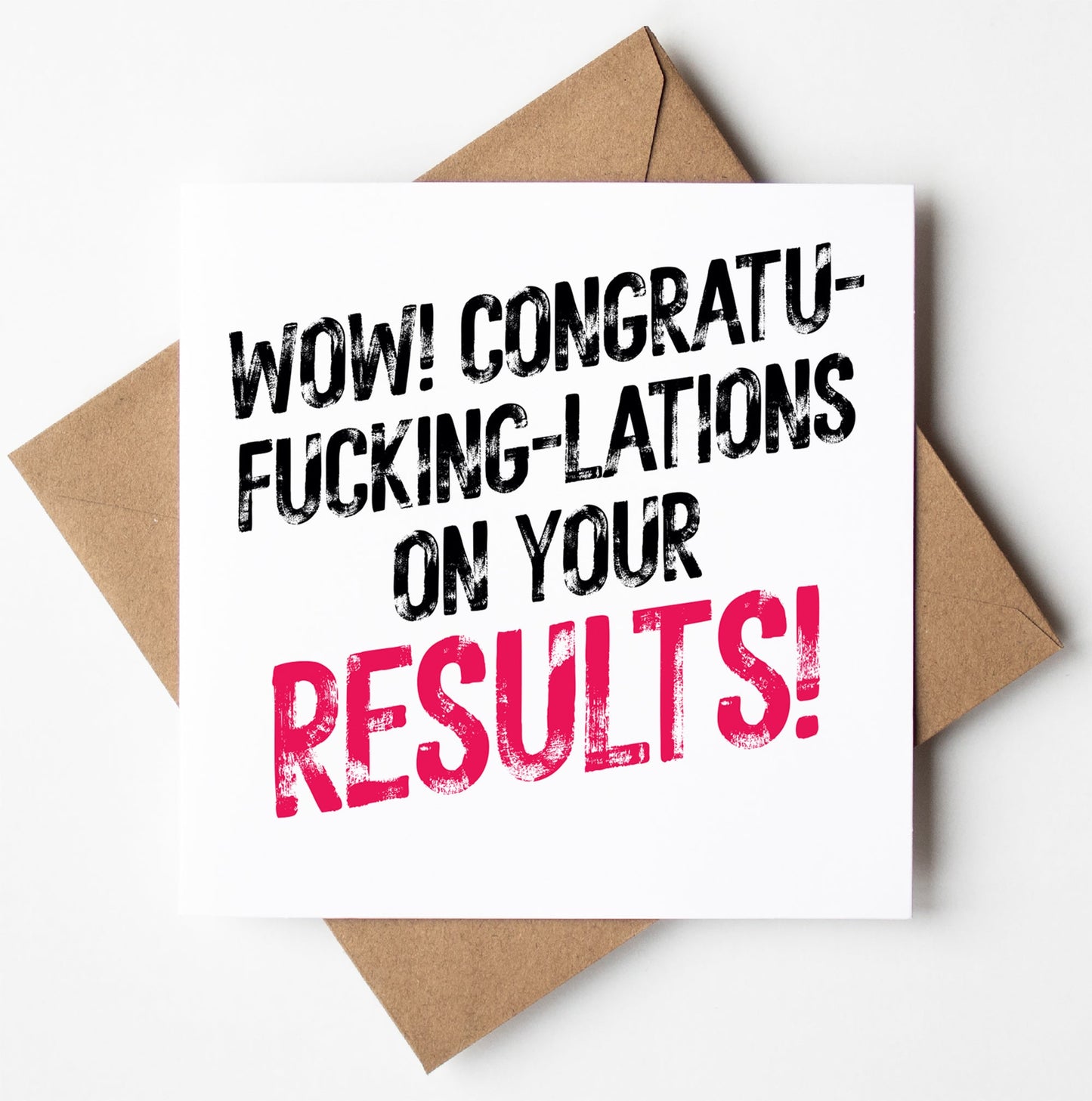 The "Congratu-fucking-lations On Your Results! Harlem Card," featuring bold black and pink lettering on a white card, rests on a brown envelope against a white backdrop. Ideal for stylishly expressing excitement.