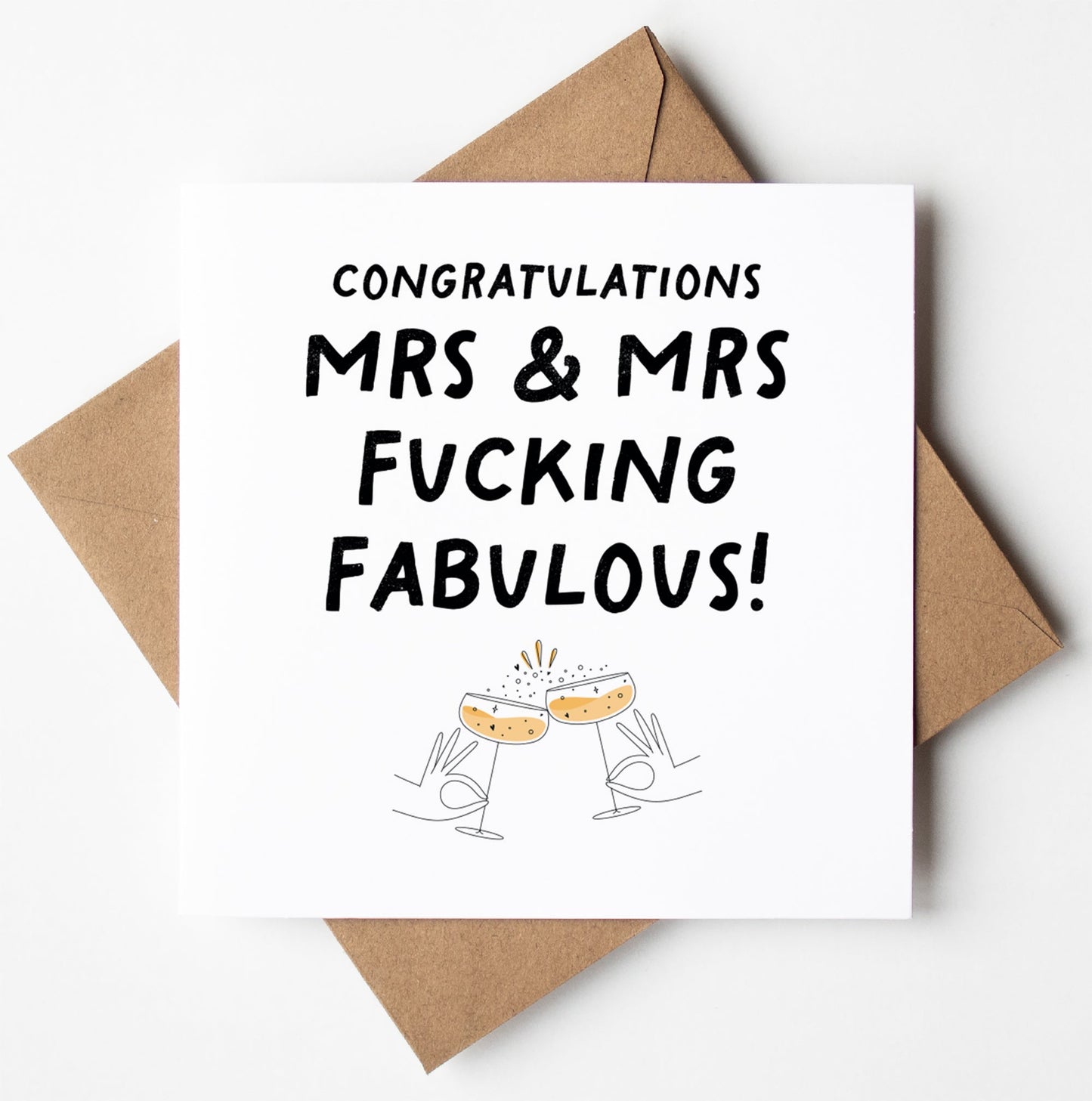 A UK-printed Mrs and Mrs Fucking Fabulous Gay Wedding Card reads "Congratulations Mrs & Mrs Fucking Fabulous!" and features an illustration of two clinking champagne glasses. The card is stylishly presented on a brown envelope, celebrating love in style.