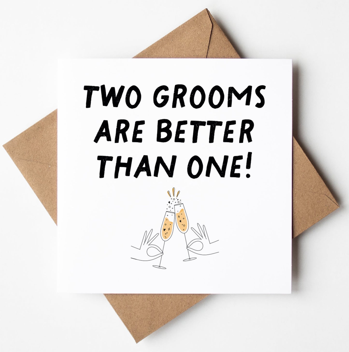 Introducing the "Two Grooms Are Better Than One! Gay Wedding Card," featuring a joyful design with "TWO GROOMS ARE BETTER THAN ONE!" above champagne glasses clinking, accentuated by celebratory sparkles and charming hand-drawn hands holding the glasses. The card is blank inside, allowing you to add your personal touch. It includes a brown envelope and is available for worldwide shipping.