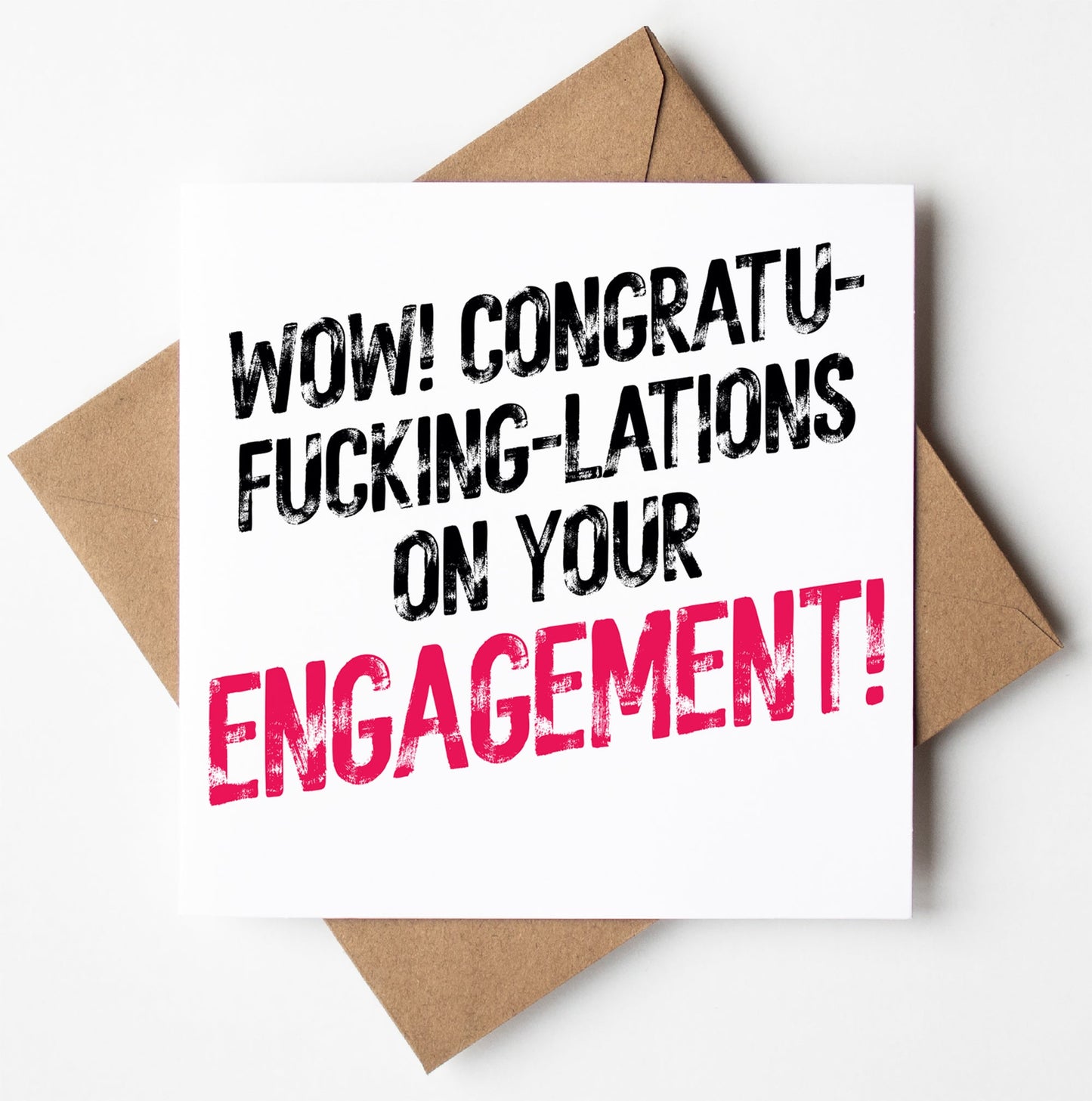 A bold and cheeky greetings card named "Congratulations On Your Engagement! Sweary Card" showcases the phrase "Wow! Congratu-fucking-lations on your engagement!" with the word "engagement" highlighted in pink, accompanied by a brown envelope.