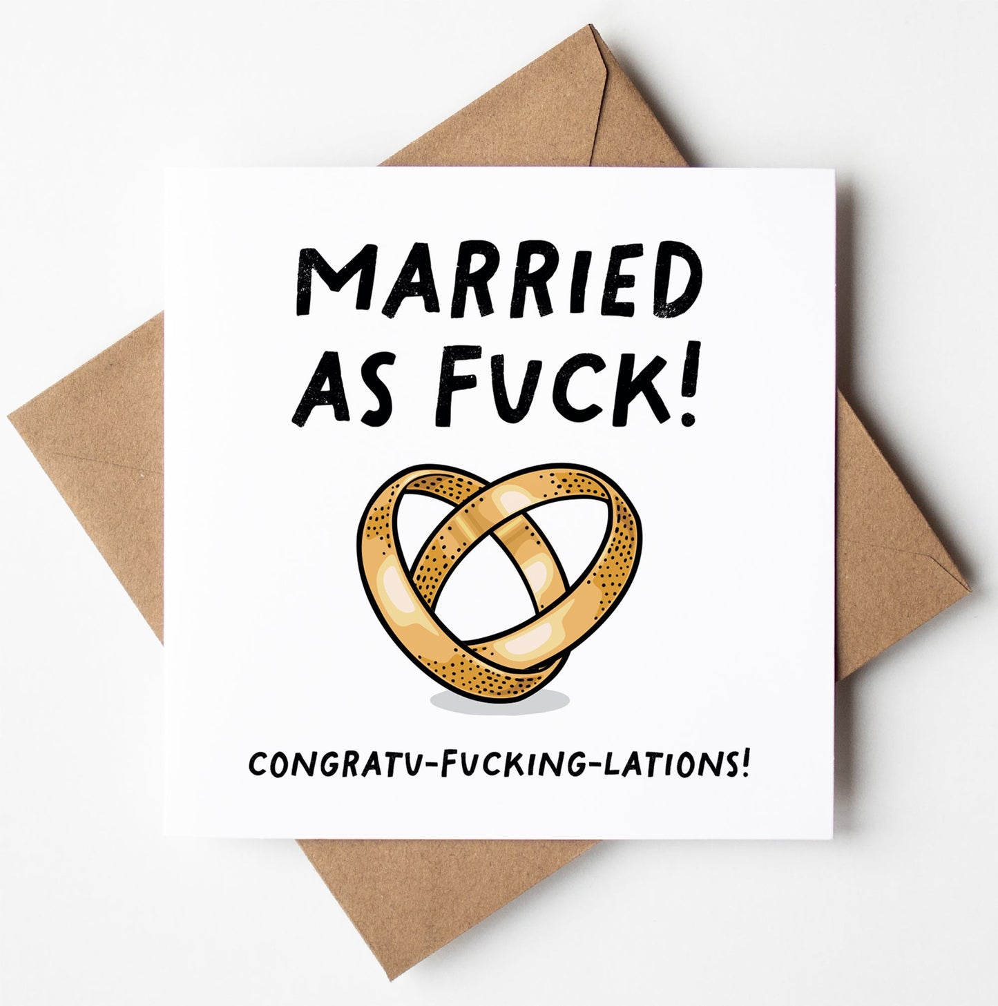 The "Married As Fuck! Congratulations Wedding Card (Same Sex)" features bold text proclaiming "Married as Fuck!" above intertwined wedding rings, ideal for a same-sex union. Below, it exclaims "Congratu-fucking-lations!" A brown envelope is included, and the entire package is wrapped in a biodegradable bag.