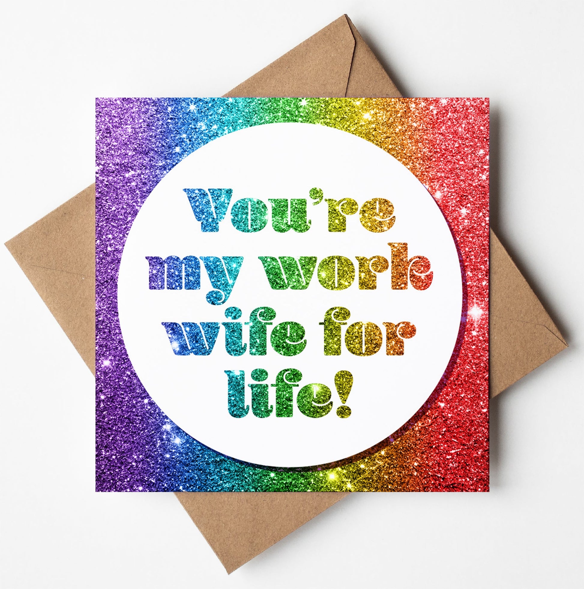 The "Work Wife For Life! Glitter Card" features a shimmering rainbow backdrop and was crafted in Wales. The center text reads, "You're my work wife for life!" This card is an ideal choice as a leaving card and comes with a brown envelope.