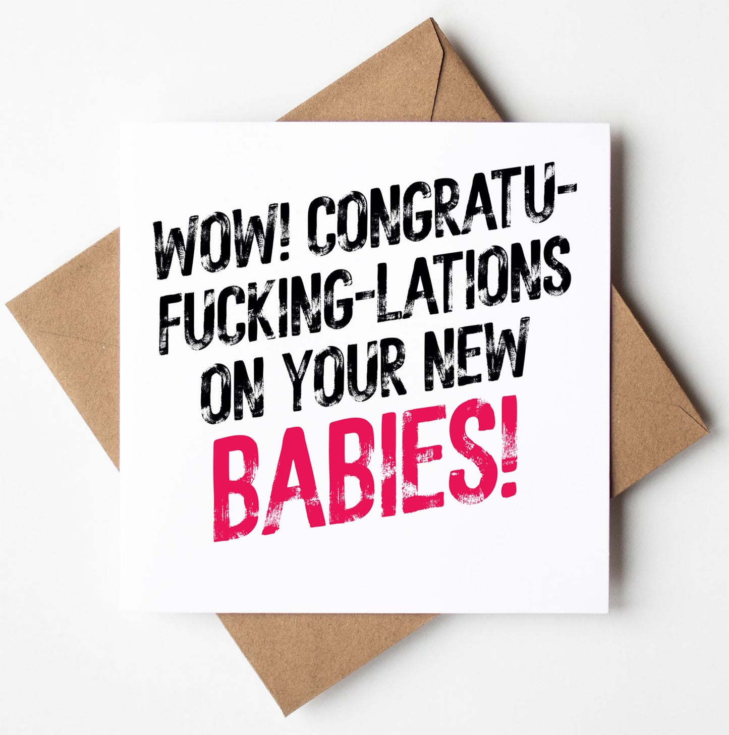 The Congrats On Your New Babies! Twins Harlem Card features bold pink "BABIES!" text on a brown envelope—an unforgettable typographic congratulations card for new twins.
