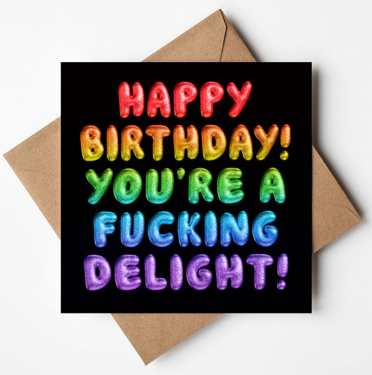 The "Happy Birthday! You're a fucking delight! Rainbow Font Card" features vibrant rainbow-colored text with a balloon-like texture on a black background, paired with a brown envelope.