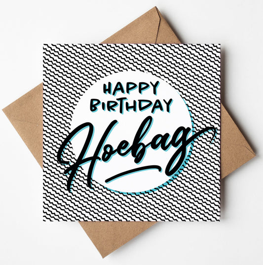 Introducing the "Happy Birthday Hoebag" Card, featuring a striking black and white zigzag pattern as its backdrop. The card showcases bold, stylized text that reads "Happy Birthday Hoebag," and comes accompanied by a brown envelope, making it perfect for worldwide shipping.