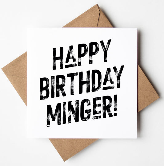 The "Happy Birthday Minger Harlem Card" features bold black text on a white background that reads, "Happy Birthday Minger!" and comes elegantly paired with a brown envelope for worldwide shipping.