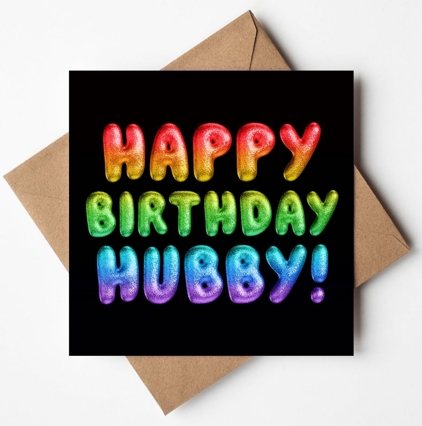 The "Happy Birthday Hubby! Rainbow Font Card" features a bold, balloon-like rainbow font against a striking black background, and includes a brown envelope for an eco-friendly gifting option, much like using a biodegradable bag.