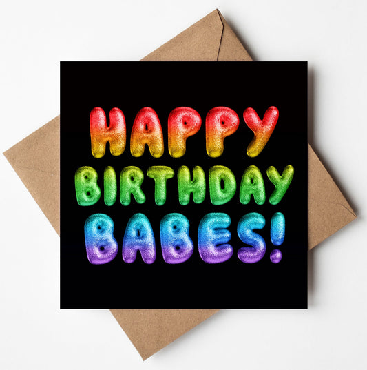 The Happy Birthday Babes! Rainbow Font Card, encased in a brown envelope, showcases textured letters declaring "Happy Birthday Babes!" against a black background. This lively card is both striking and available with worldwide shipping options, making it easy for your heartfelt wishes to reach loved ones anywhere.