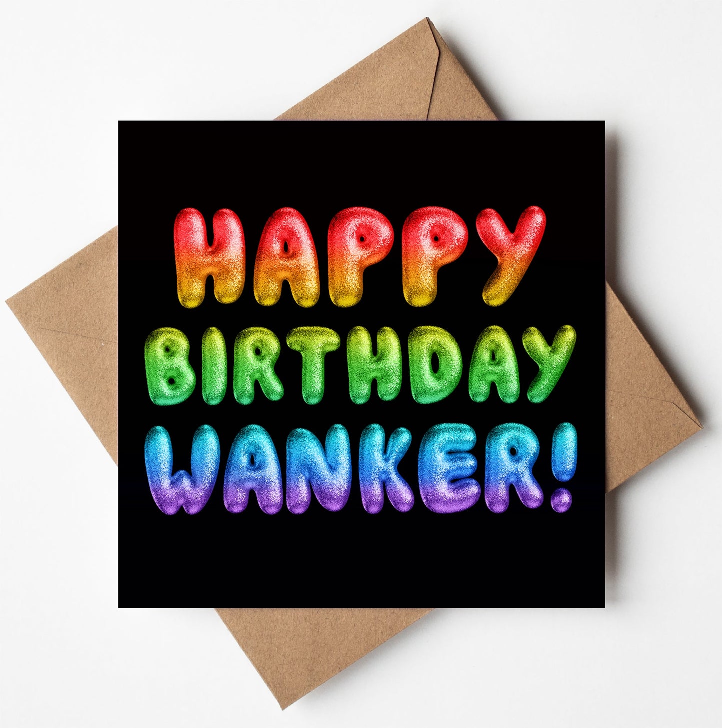 The Happy Birthday Wanker! Rainbow Font Card features vibrant, balloon-shaped letters spelling out "Happy Birthday Wanker!" against a black background. This playful birthday card, set on a brown envelope, is sure to catch attention and comes conveniently packaged in an eco-friendly biodegradable bag for easy storage.