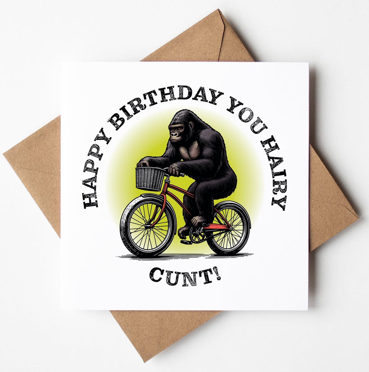A humorous birthday card named "Happy Birthday You Hairy Cunt! Gorilla Card" showcases a gorilla riding a bicycle with the bold message "Happy Birthday You Hairy Cunt!" encircling the image. This cheeky card is carefully packaged in a brown envelope.