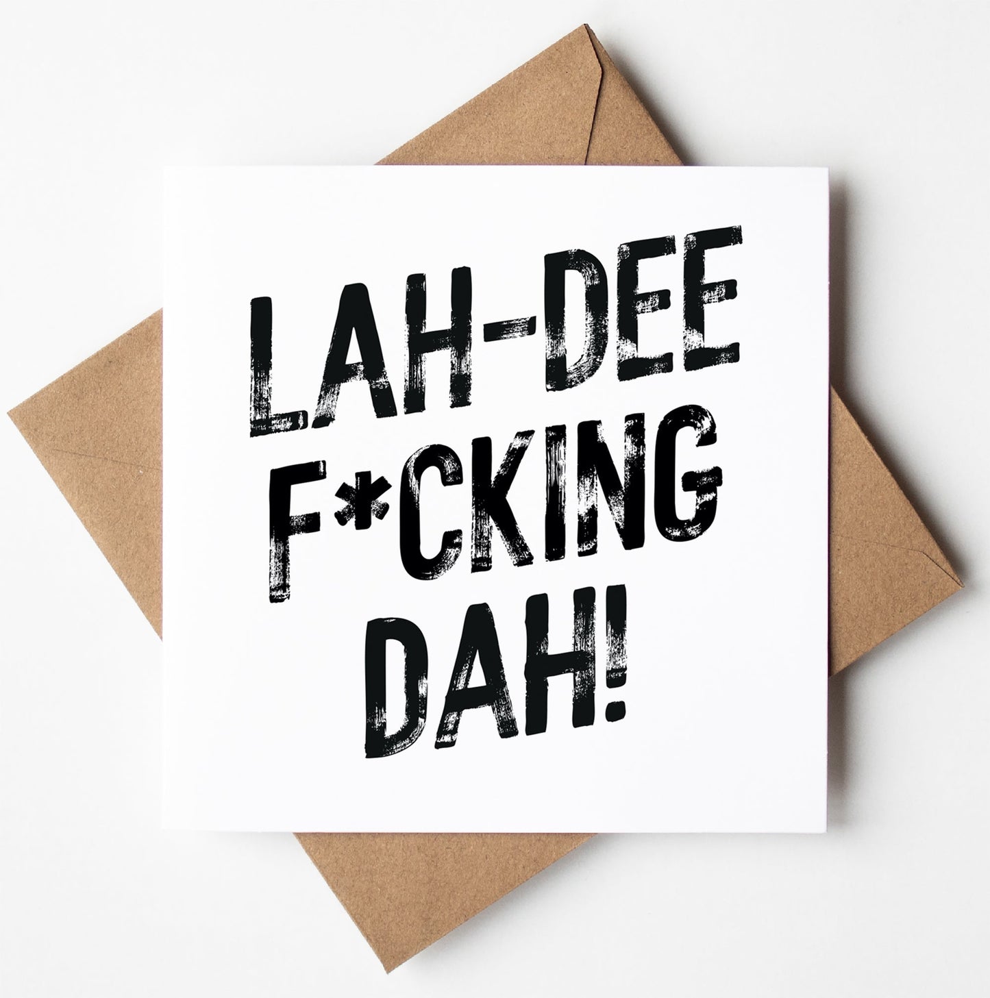 The Lah-Dee F*cking Dah! Harlem Card features bold black text on a white card, paired with a brown envelope. Perfect for any occasion, this unique greetings card ships worldwide.
