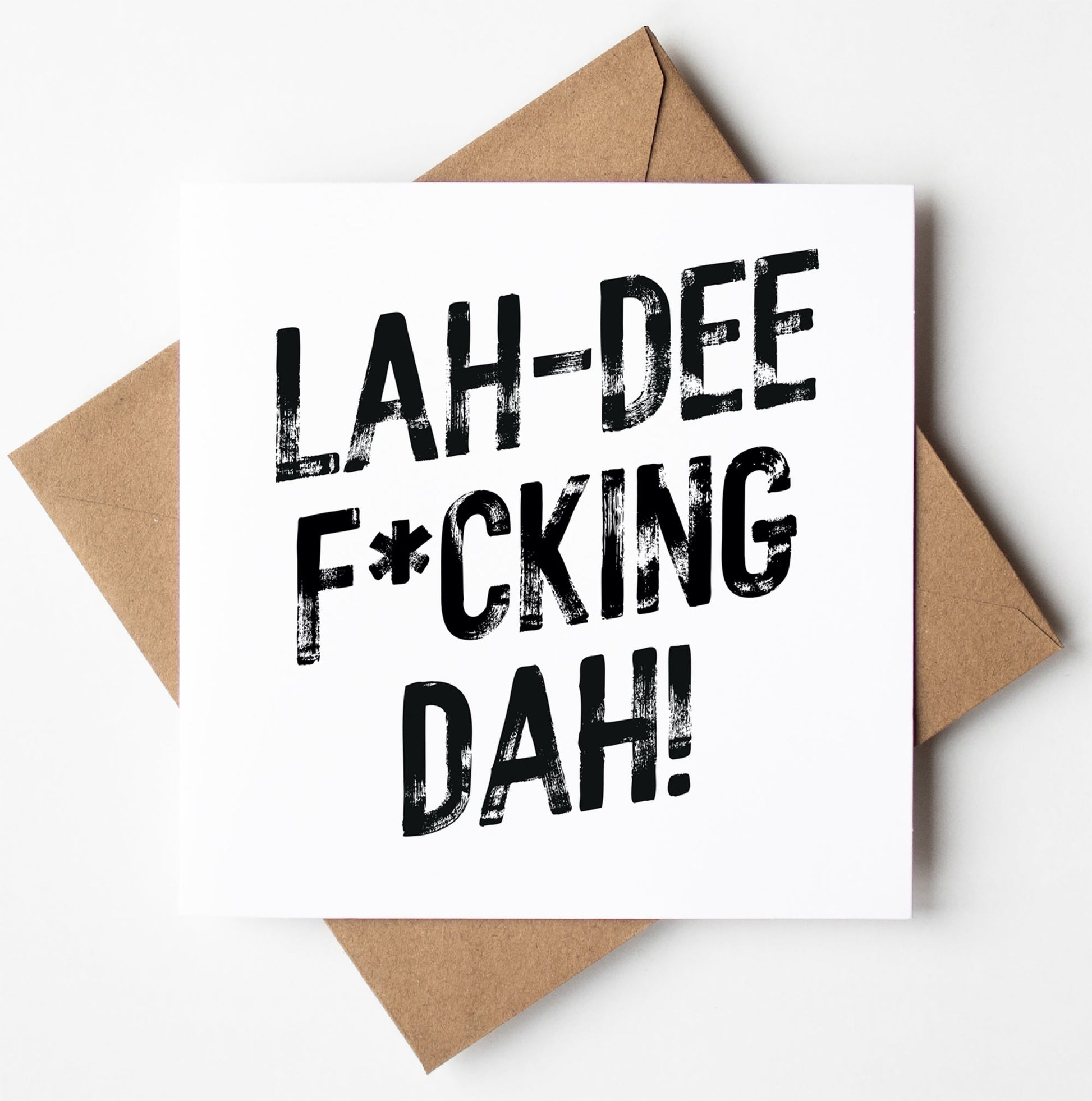 The Lah-Dee F*cking Dah! Harlem Card features bold black text on a white card, paired with a brown envelope. Perfect for any occasion, this unique greetings card ships worldwide.