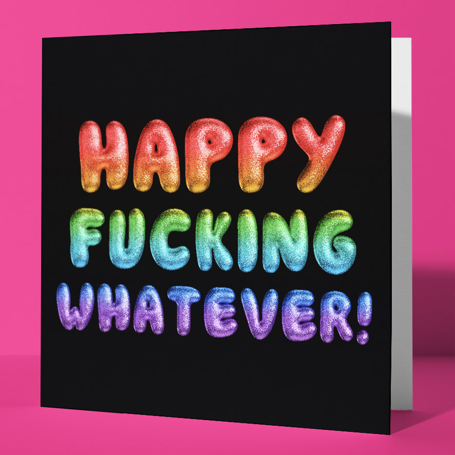 The Happy Fucking Whatever! Rainbow Font Card features a bold, sweary message in colorful puffy letters against a black background, standing upright on a bright pink surface—perfect for any irreverent celebration.