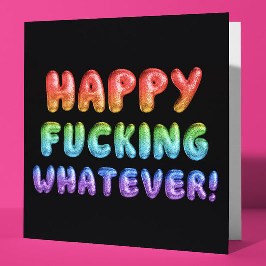 The Happy Fucking Whatever! Rainbow Font Card features a bold, sweary message in colorful puffy letters against a black background, standing upright on a bright pink surface—perfect for any irreverent celebration.
