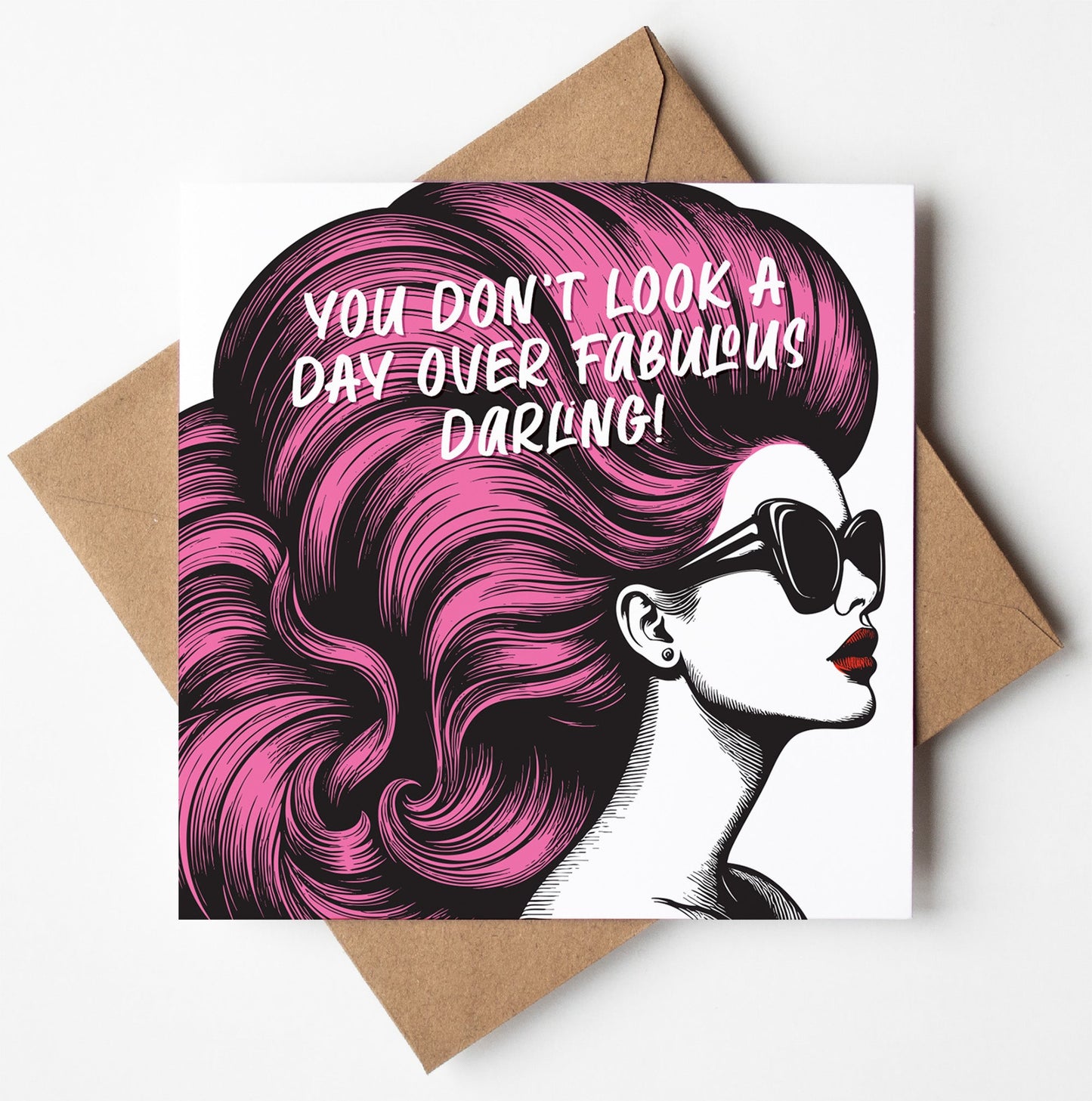 The "You Don't Look A Day Over Fabulous Darling! Vintage Babes Happy Birthday Card" features a woman with bright pink hair and sunglasses, plus the message: "You don’t look a day over fabulous, darling!" Comes with a brown envelope—perfect for her birthday.