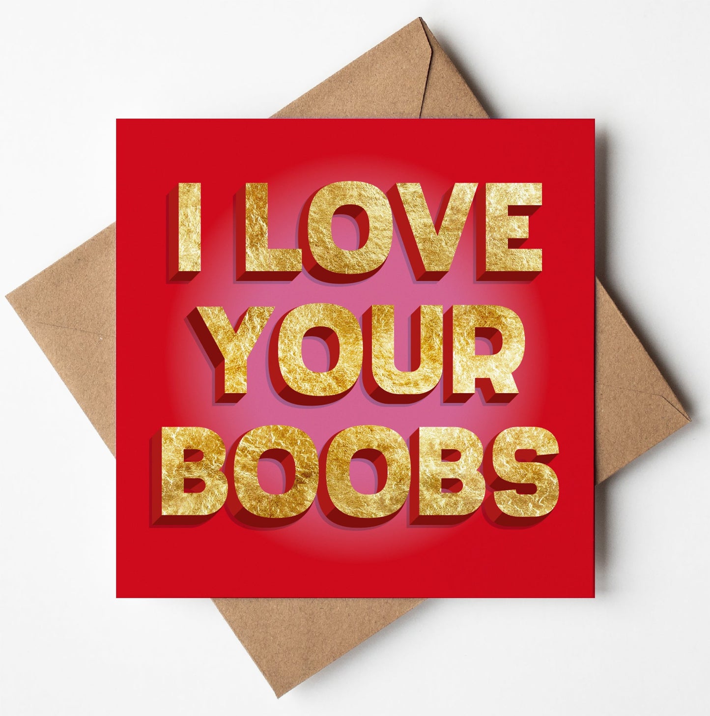 The "I Love Your Boobs Card" is a red Valentine card with bold, gold 3D text. The card rests on a brown envelope against a white background, capturing the playful spirit of a funny anniversary gift.