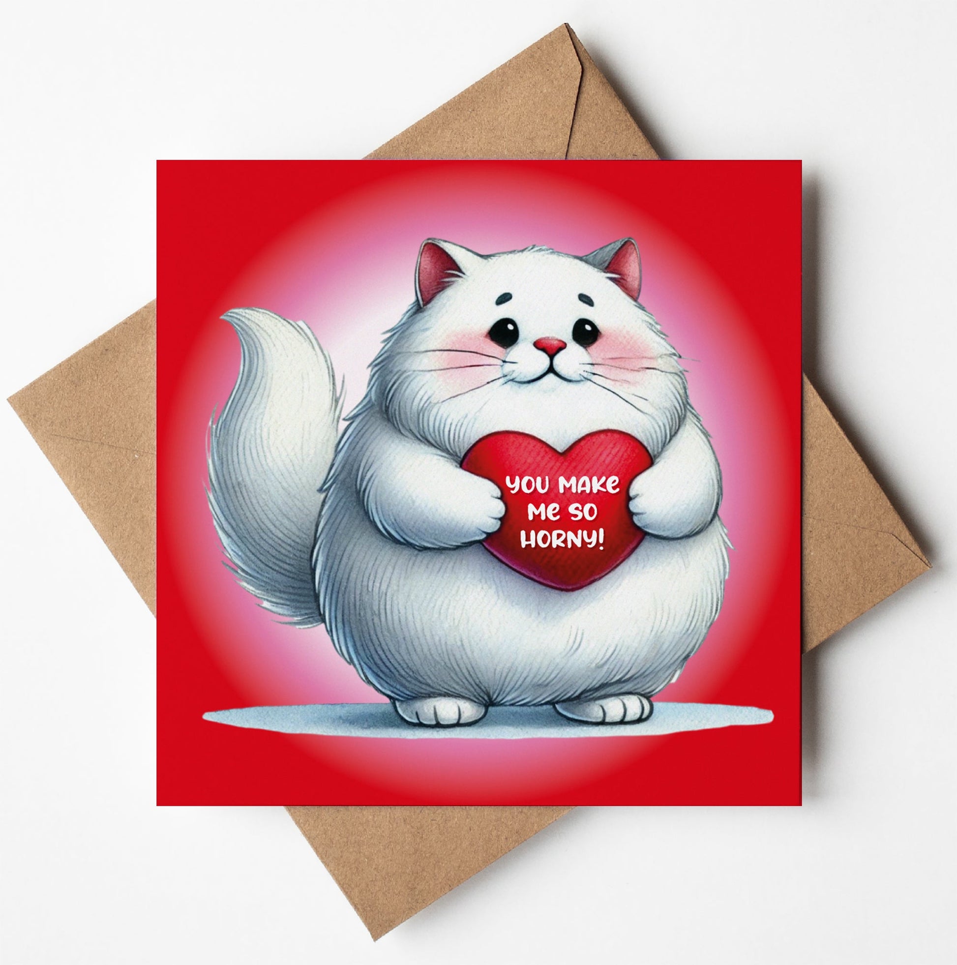 The "You Make Me So Horny! Cute Kitten Card" features a fluffy white cat holding a heart with the text against a red backdrop, perfectly displayed atop a brown envelope to bring smiles and laughter to your special someone's face this Valentine's Day.