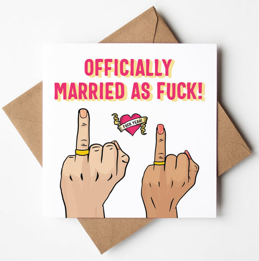 The "Officially Married As Fuck Card (M/F)" showcases an illustration of two hands wearing wedding rings while displaying middle fingers. Between them is a heart with a banner that boldly states "FUCK THEM!" Above the image, the card announces in large text, "OFFICIALLY MARRIED AS FUCK!" and is paired with a brown envelope against a white background.