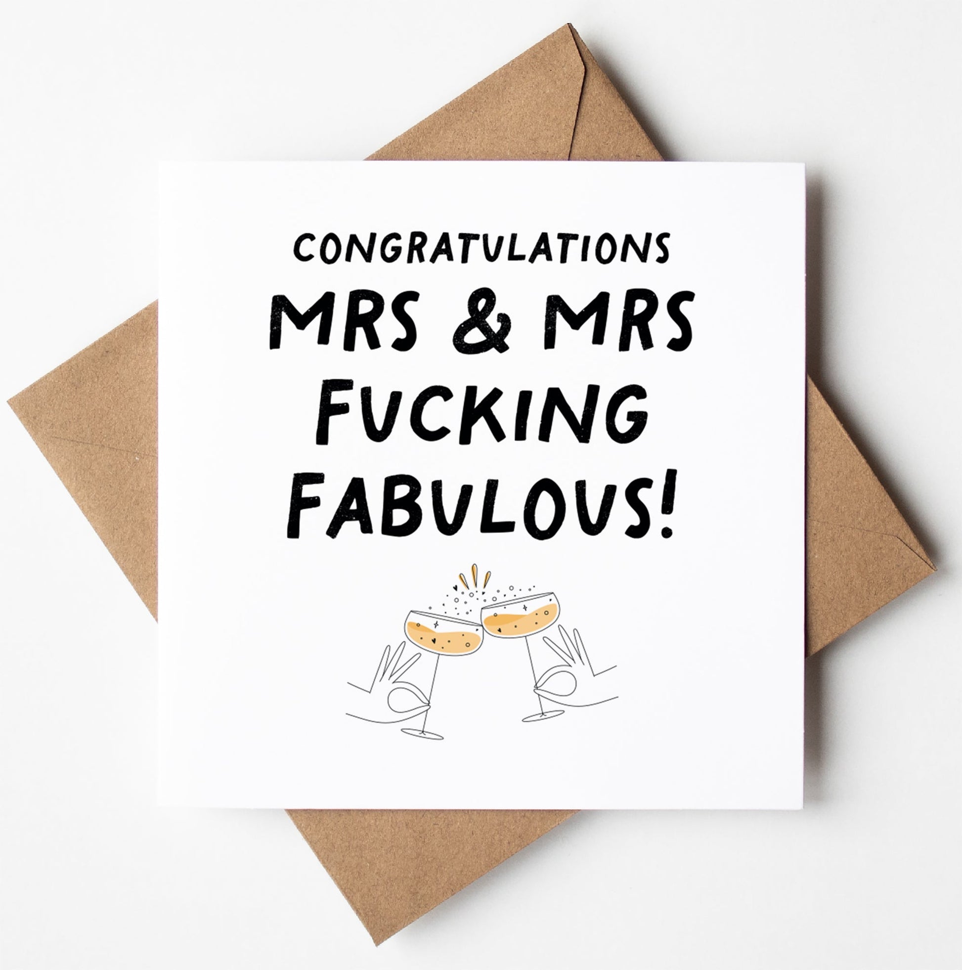 A UK-printed Mrs and Mrs Fucking Fabulous Gay Wedding Card reads "Congratulations Mrs & Mrs Fucking Fabulous!" and features an illustration of two clinking champagne glasses. The card is stylishly presented on a brown envelope, celebrating love in style.