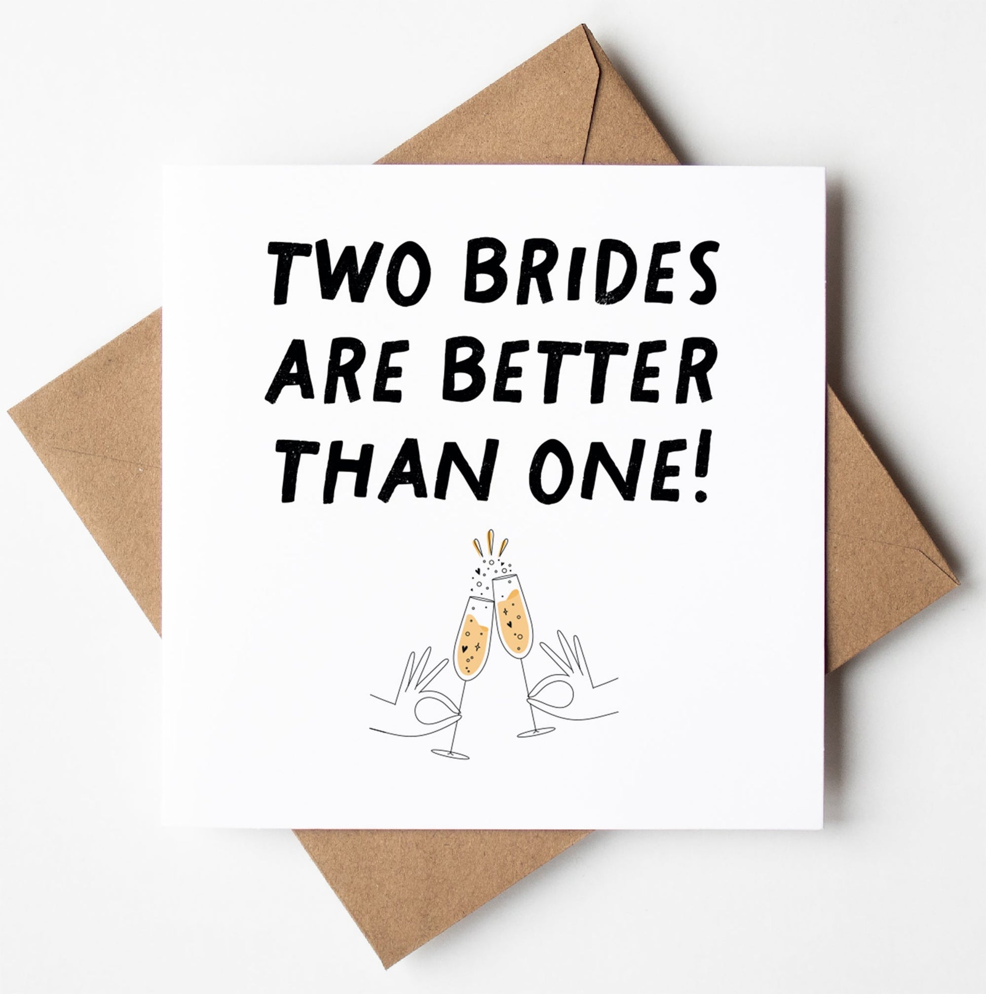The "Two Brides Are Better Than One!" Gay Wedding Card is beautifully designed with the phrase above illustrated clinking champagne glasses. It comes with a brown envelope, set against a white backdrop, and is carefully packaged in a biodegradable bag. The inside of the card is left blank for your personal message.