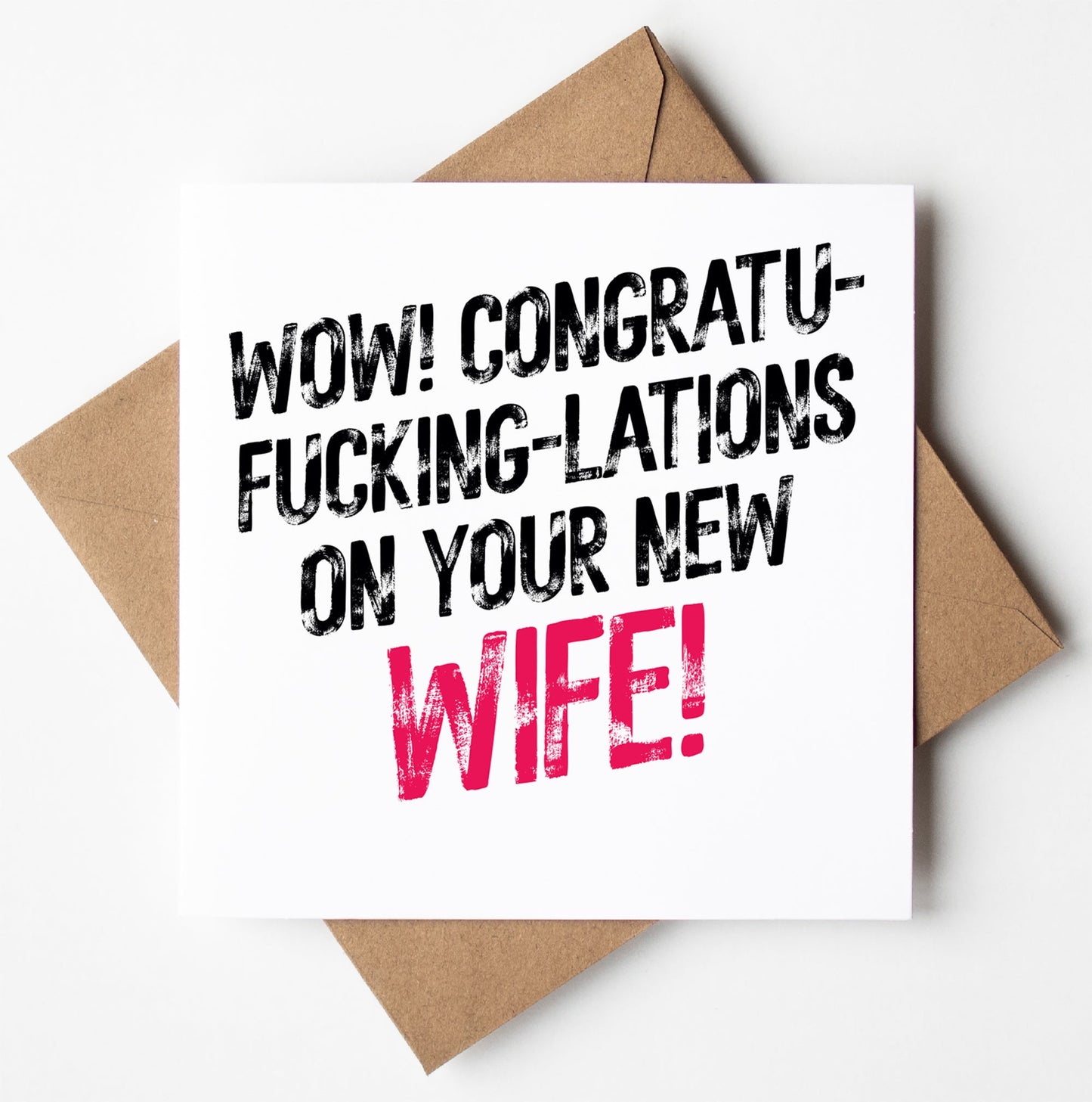 A Harlem Wedding Card with a bold twist arrives in a brown envelope, featuring black and pink text that shouts, "WOW! CONGRATU-FUCKING-LATIONS ON YOUR NEW WIFE!" Designed in Wales, this card is perfect for those wanting to make a statement.