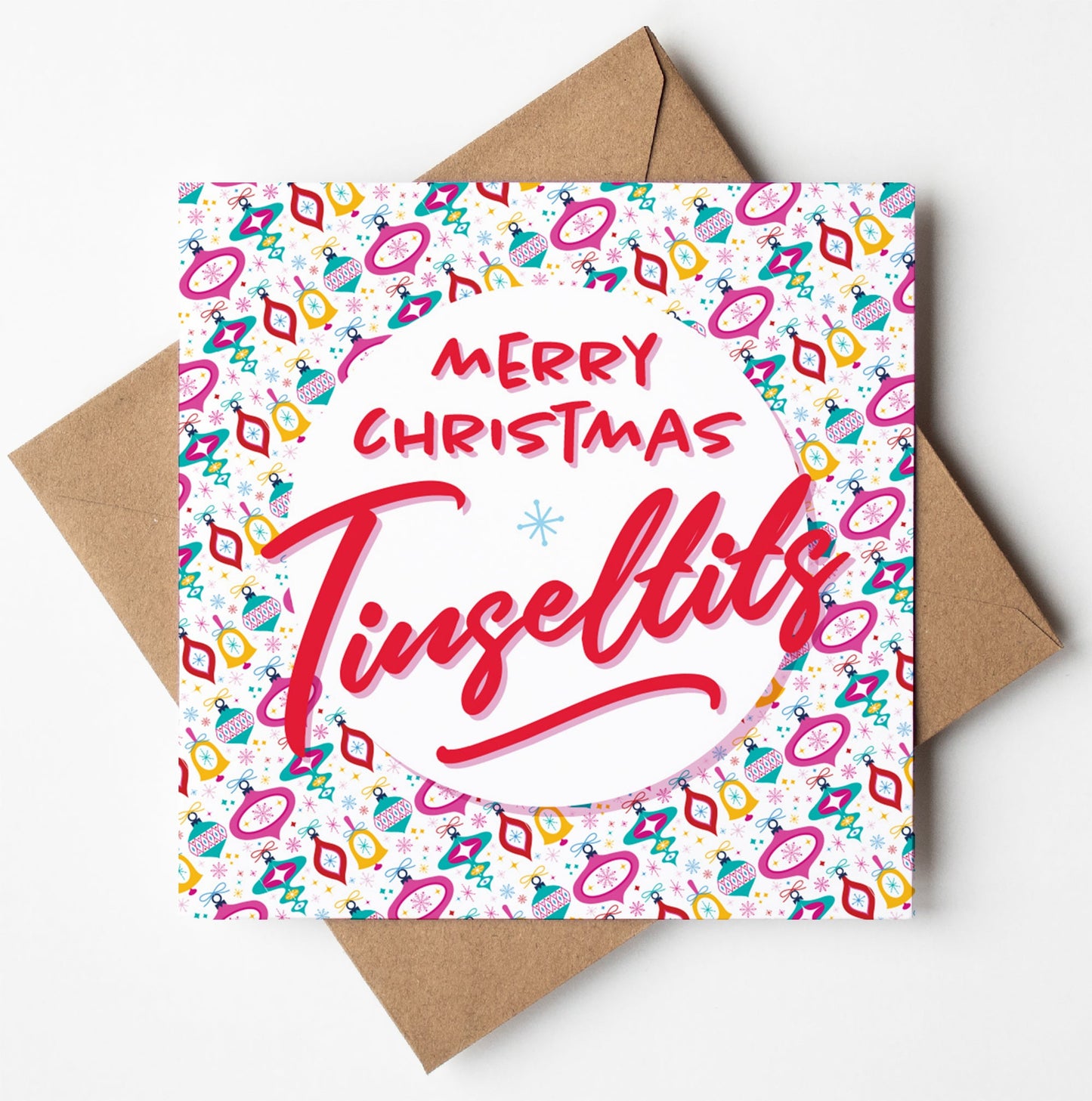 A festive Christmas card with "Merry Christmas Tinseltits" in bold, red text, surrounded by a colorful, vintage-inspired pattern reminiscent of classic holiday designs. This greetings card is paired with a brown envelope.