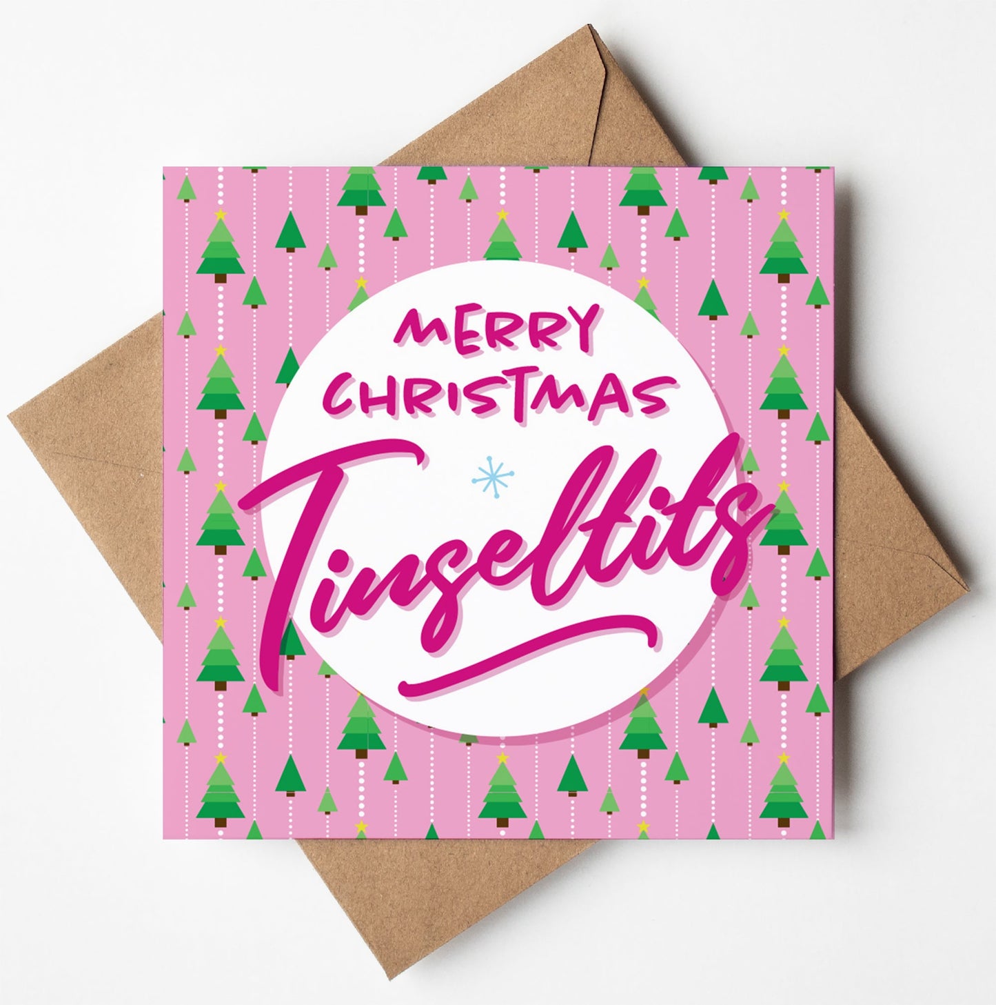The Merry Christmas Tinseltits Trees Pink Card showcases small green trees arranged diagonally on a pink background and comes with a biodegradable brown envelope. A white circle in the center displays the words "Merry Christmas Tinsel Tits" in pink text, making it an ideal choice for spreading cheer internationally.