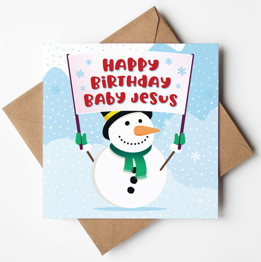 The Happy Birthday Baby Jesus Christmas Card depicts a snowman holding a banner with the same message amidst falling snowflakes and a snowy landscape. It is paired with a brown envelope, available for worldwide shipping, and packaged in an eco-friendly biodegradable bag.