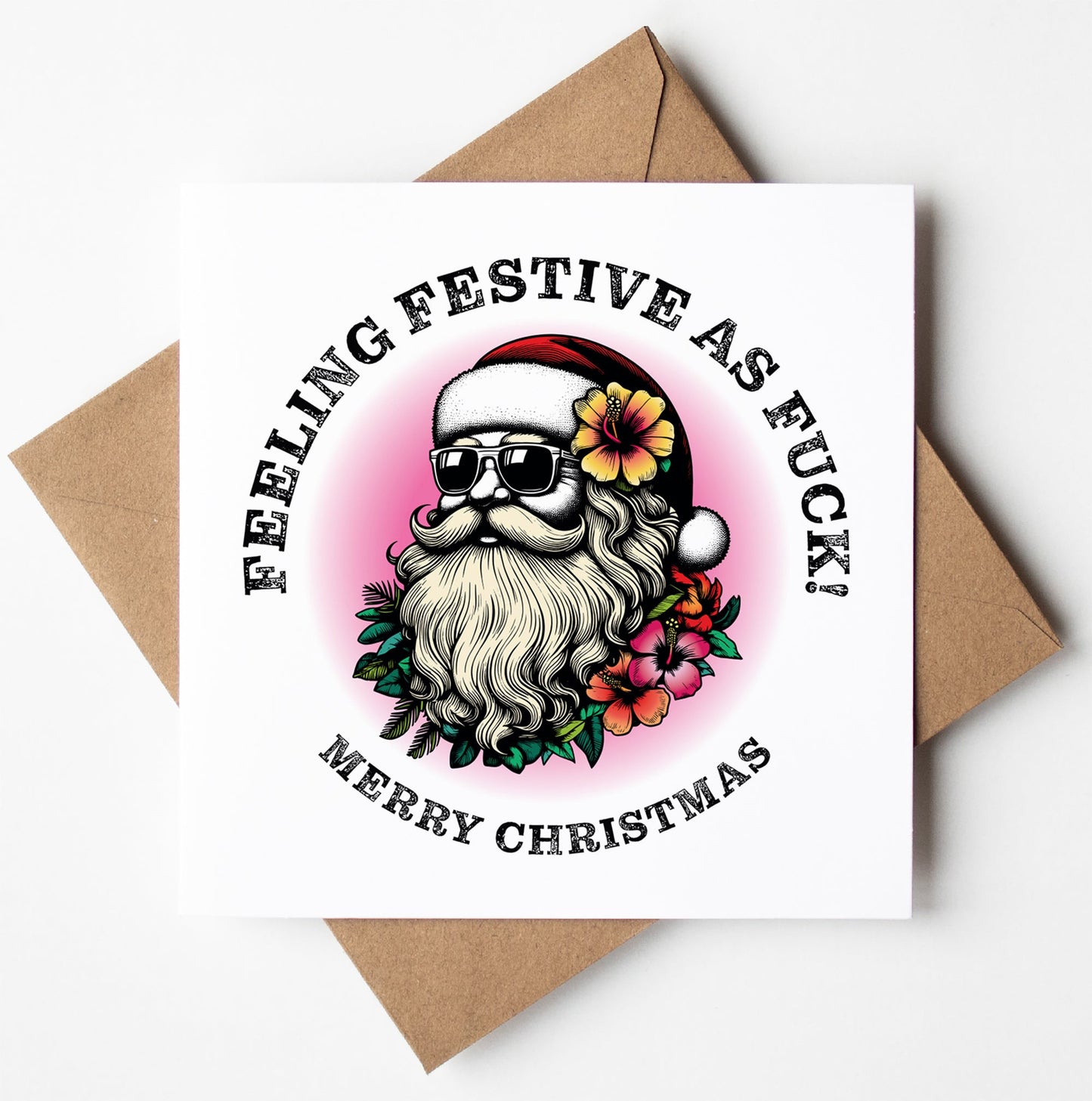 The "Sunglass Santa's Feeling Festive As Fuck! Christmas Card" showcases a humorous Santa sporting sunglasses and a red hat, amidst tropical flowers. The card features the text "Feeling Festive As F*ck! Merry Christmas" in a circular design, ideal for fans of cheeky Xmas humor. It comes paired with a brown envelope.
