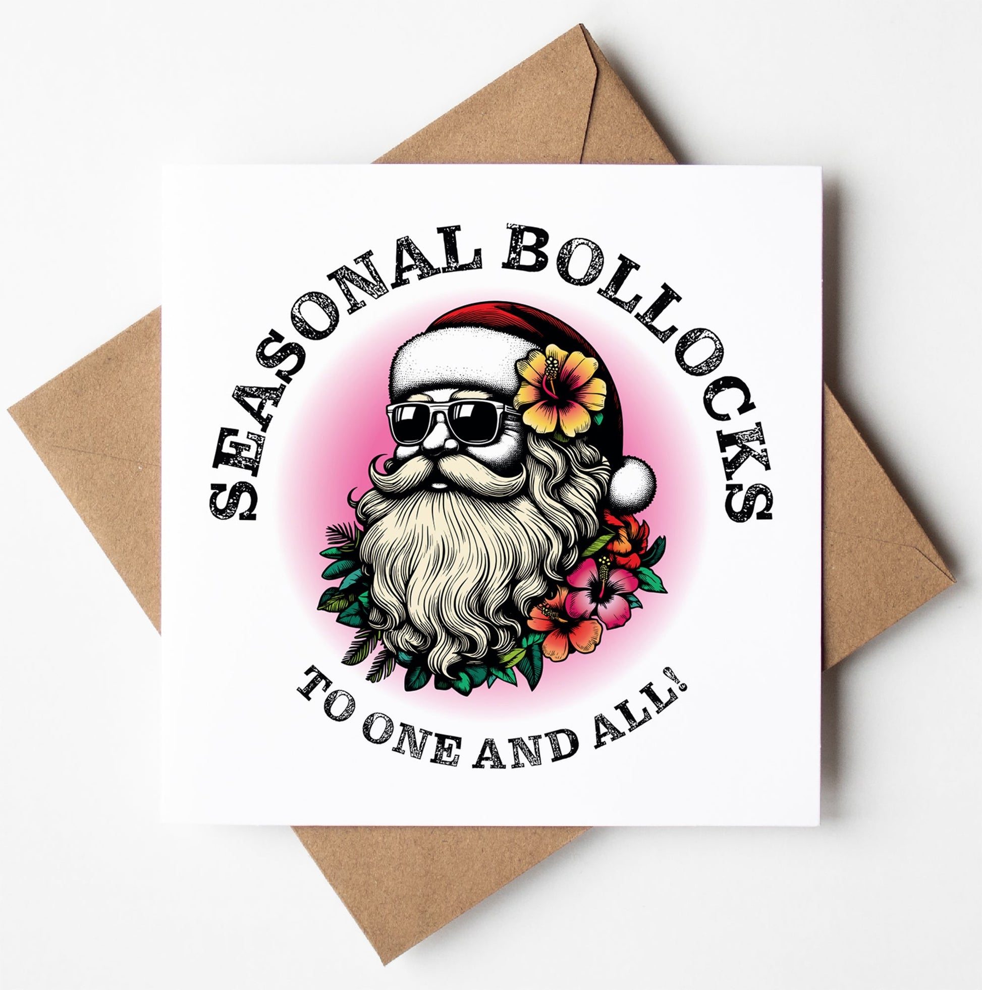 The "Sunglass Santa's Seasonal Bollocks To One And All! Xmas Card" features a humorous illustration of Santa Claus wearing sunglasses and a Santa hat, encircled by flowers. The card is emblazoned with the phrase "Seasonal Bollocks" above and "To One and All!" below. This adult Christmas card rests on a brown envelope, offering a witty twist to the classic seasonal greeting.
