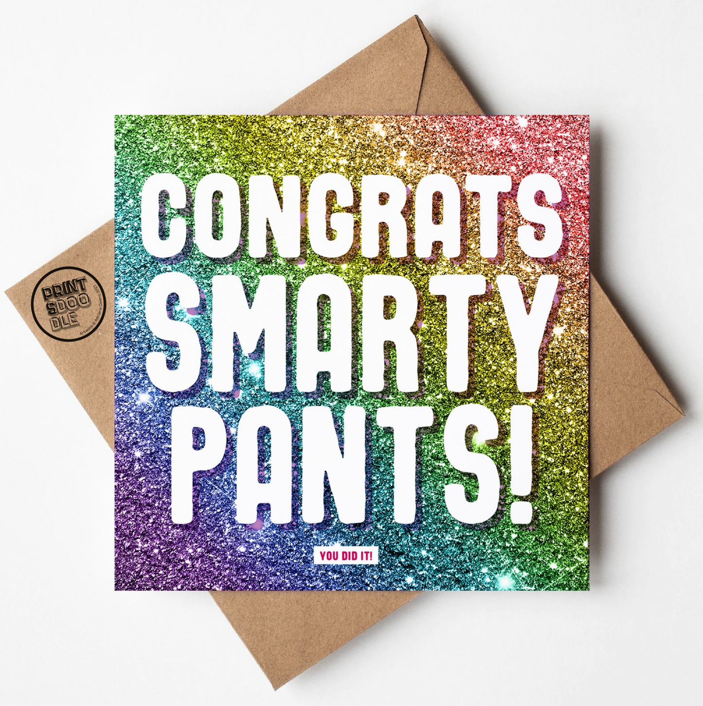 The "Congrats Smarty Pants" card features a rainbow glitter background with bold white "CONGRATS SMARTY PANTS!", atop a brown envelope. A small label at the bottom says, "YOU DID IT!"—perfect for graduation, exam results, new job, or passing your driving test.